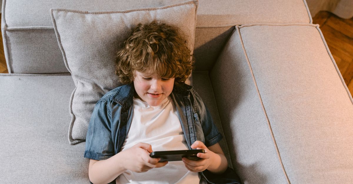 Kid-lying-on-couch-watching-video-on-phone-.jpg
